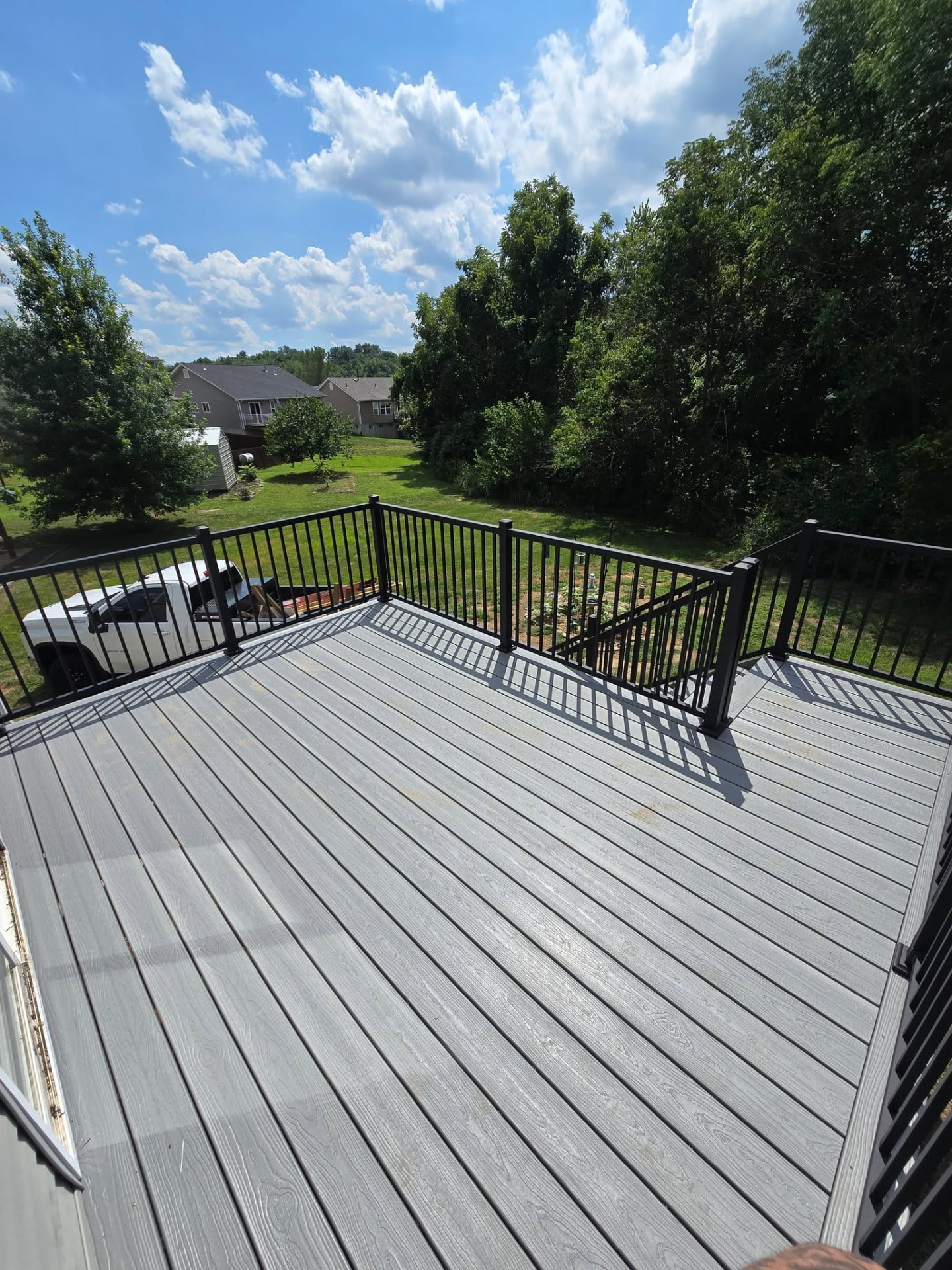 Cape Cod Grey composite boards with maintenance-free black aluminum handrails, looking over the backyard by B&R Construction