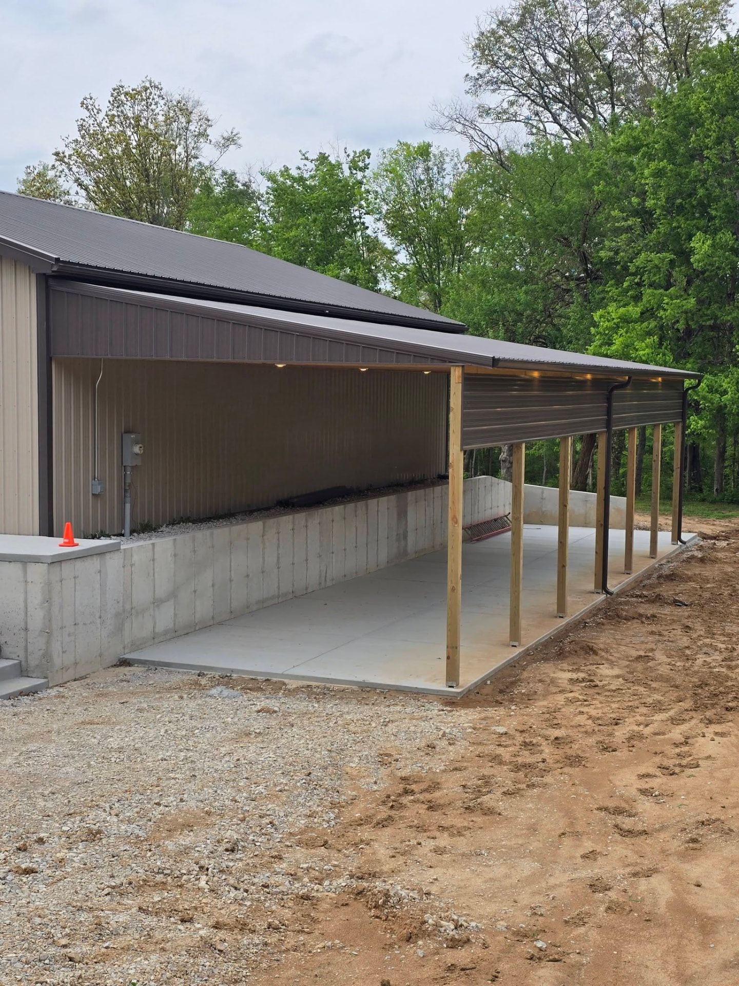 Wood posts and metal roofing over the new concrete pad by B&R Construction