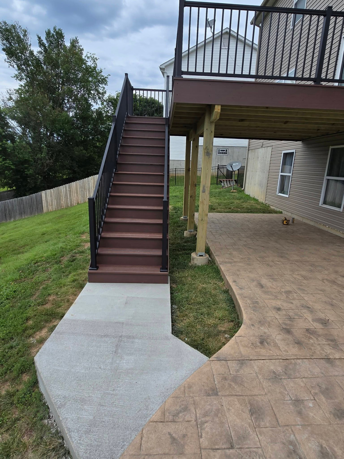 Full set of composite stairs with concrete landing connecting to the existing pad by B&R Construction