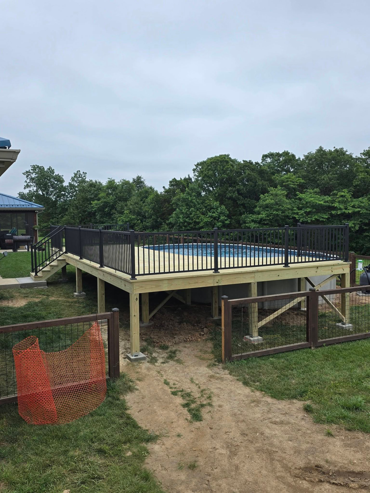 450 sq ft treated pool deck with black aluminum handrails by B&R Construction