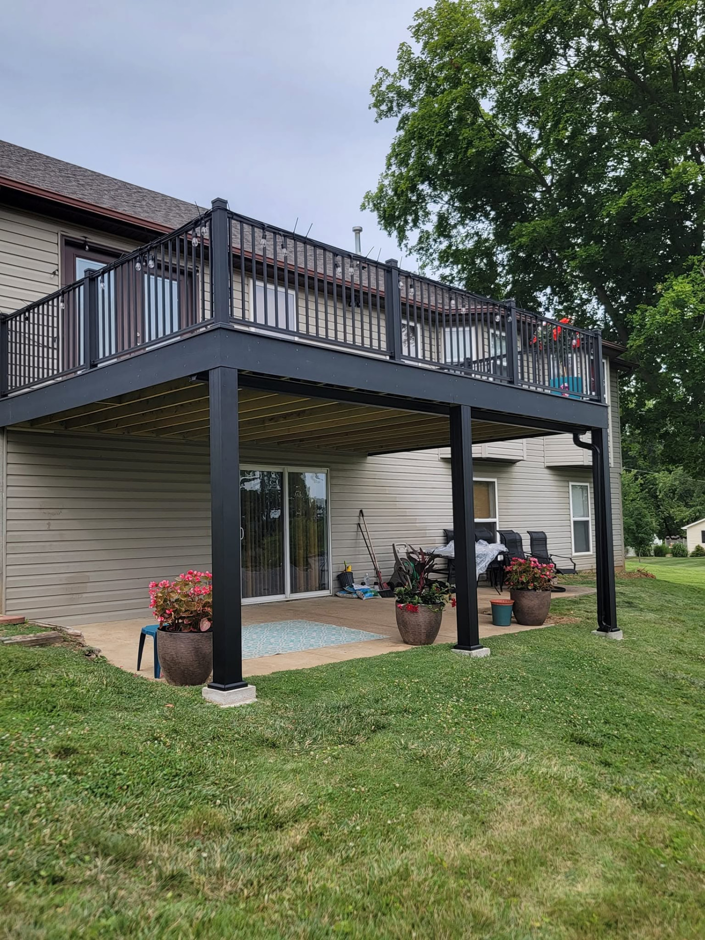 The 20' × 14' Sedona deck from the yard — skirt boards all around and the 6×6 posts wrapped in black aluminum to match the handrails by B&R Construction