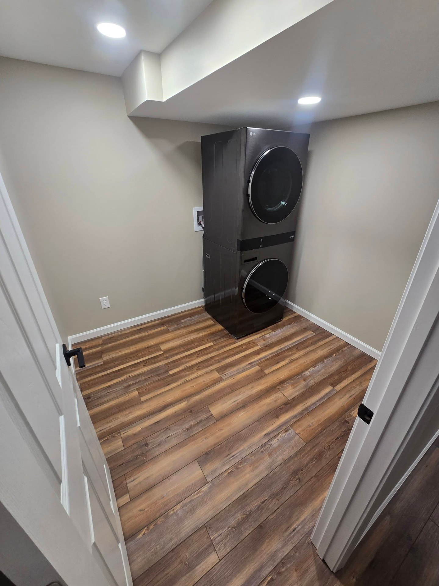 Oversized closet/laundry room with stacked washer and dryer by B&R Construction