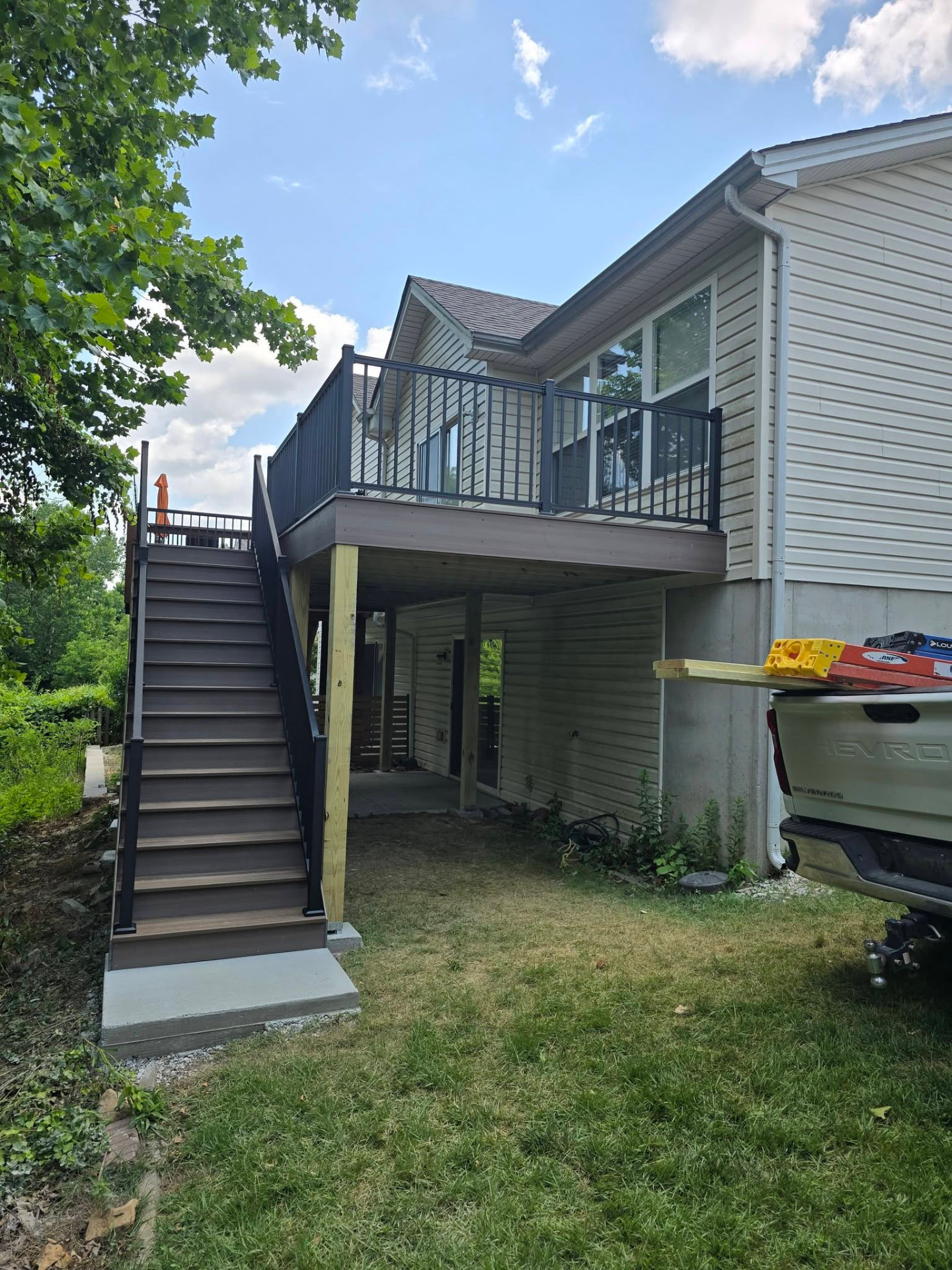 Envision Rockaway Beach composite deck with black aluminum rail and composite stairs by B&R Construction