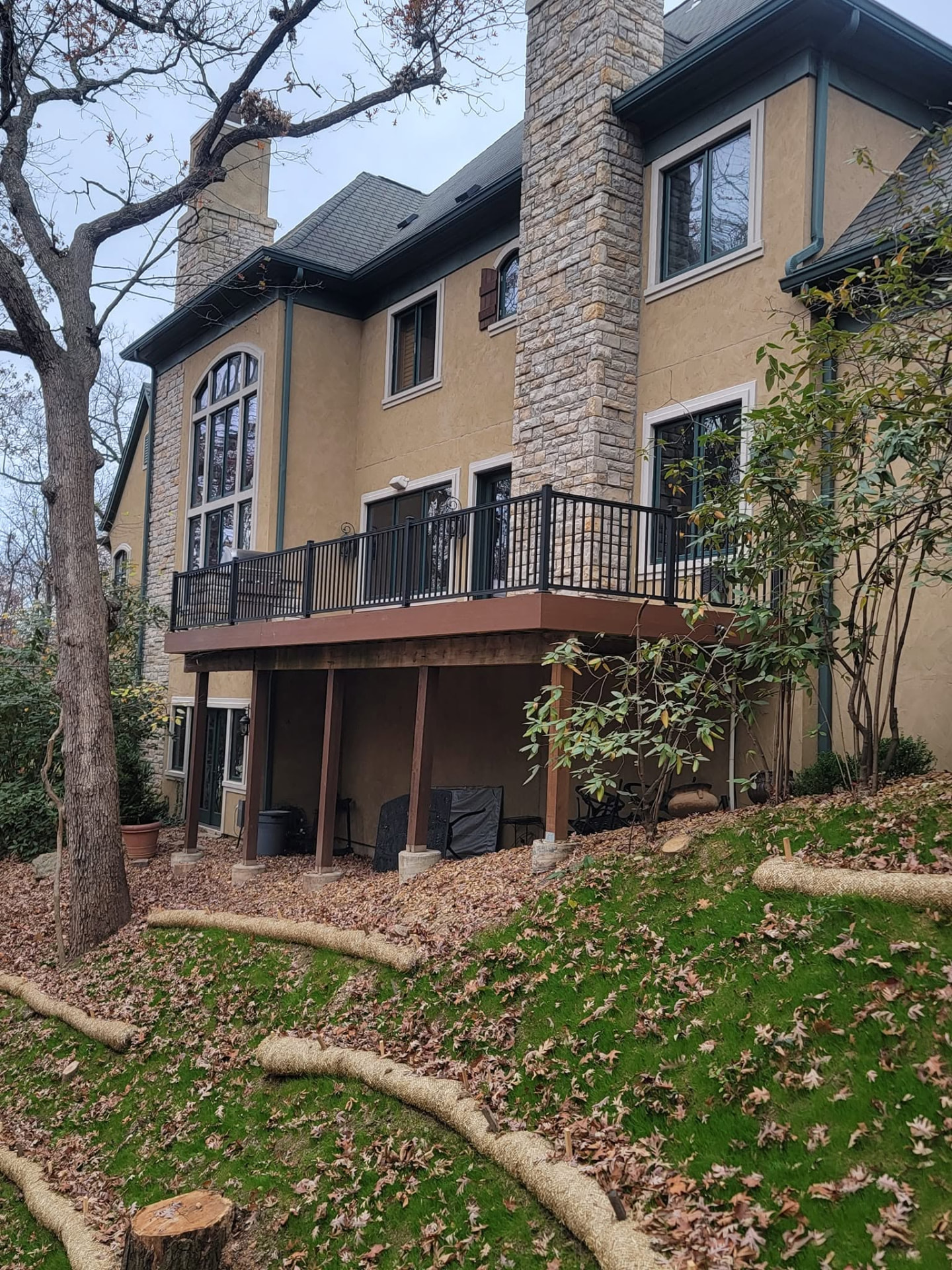 The finished 32' × 12' composite deck from the yard — new boards and rail, same favorite spot by B&R Construction