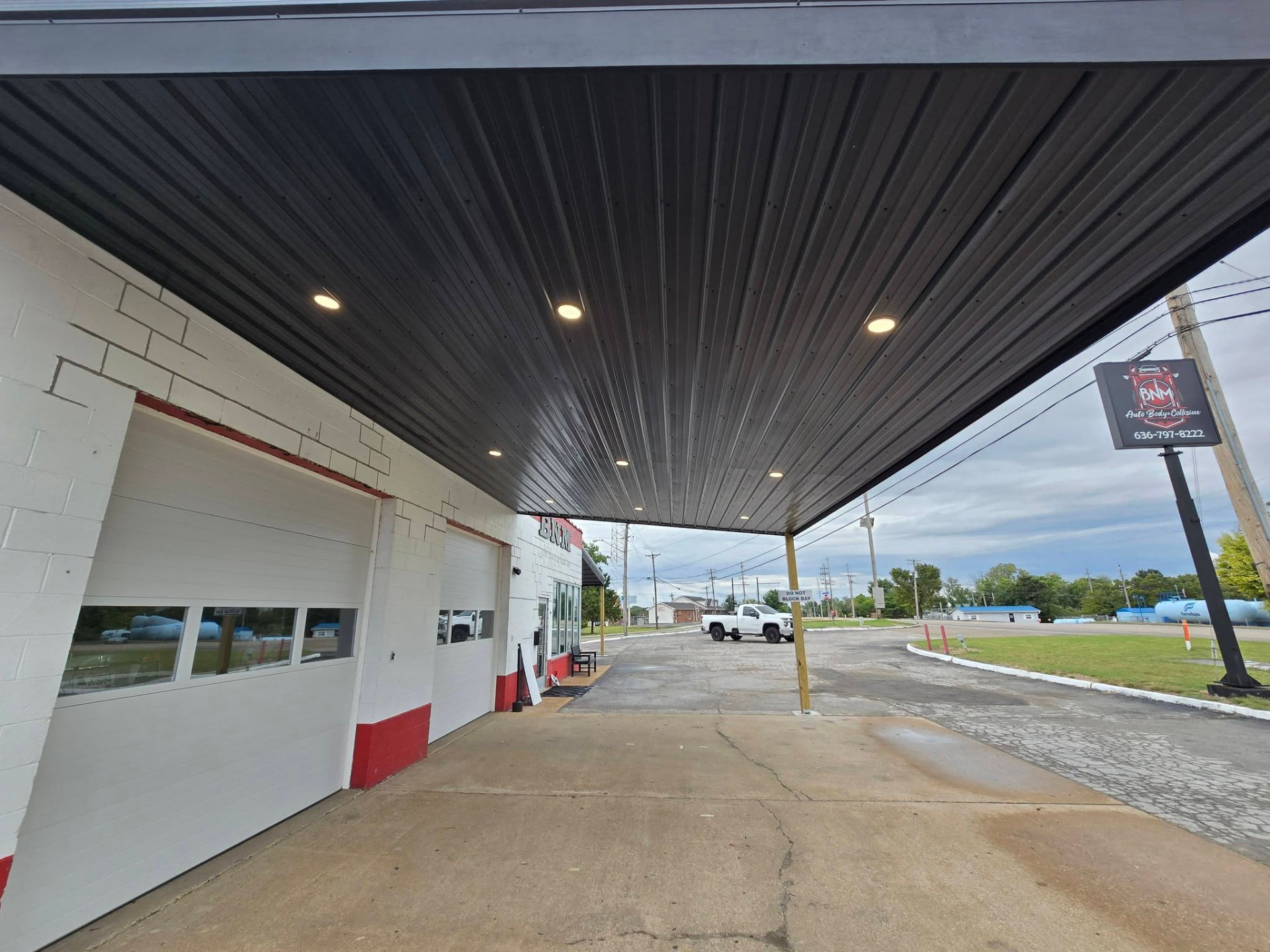 Lean-to underside with black metal ceiling and recessed lighting by S.C. French Electrical Services — extra light and safety for customers dropping cars off by B&R Construction in Hillsboro, MO