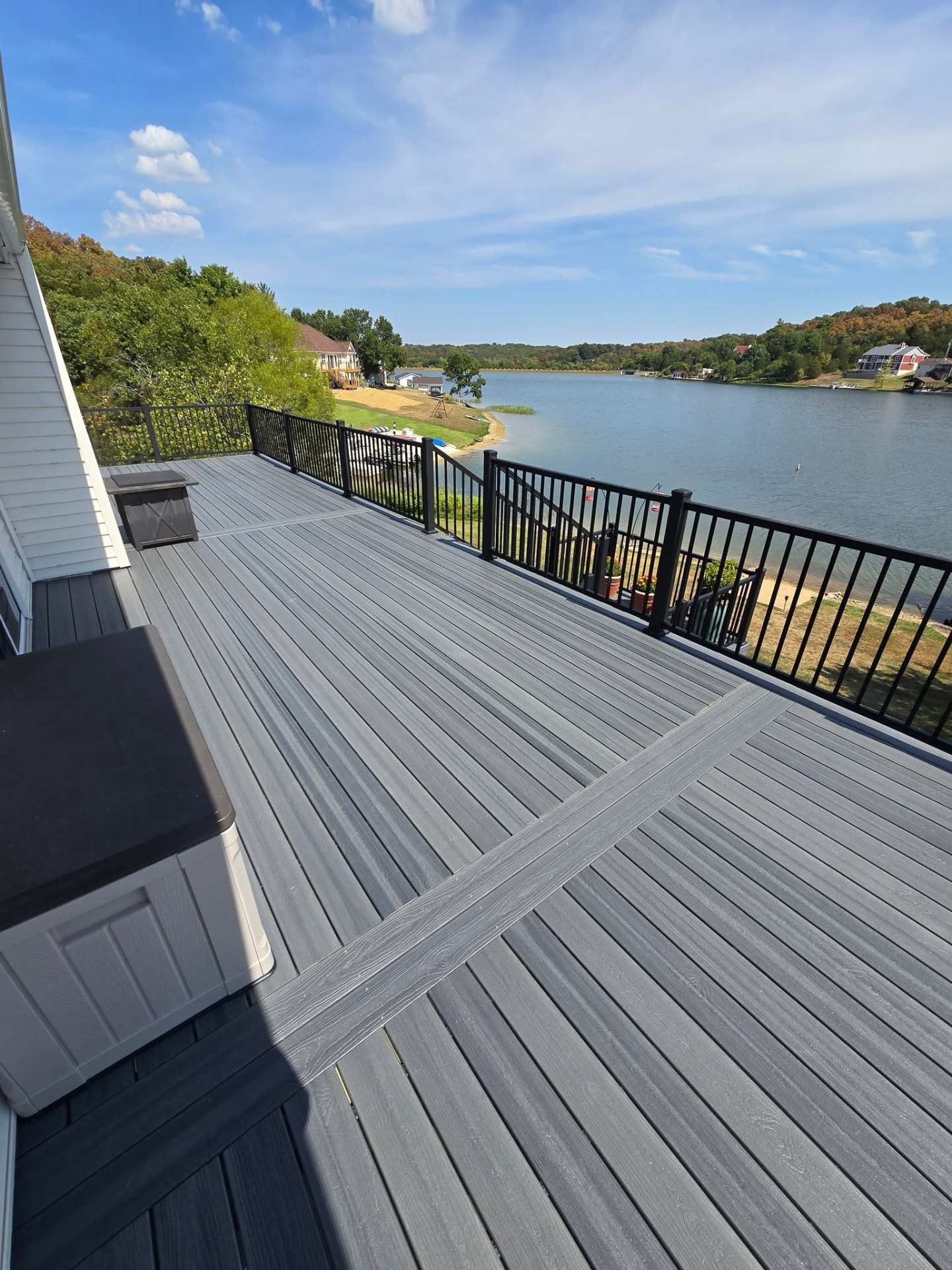50' × 12' maintenance-free composite deck in Graywood — picture-framed with double dividers and black aluminum handrails, overlooking the lake by B&R Construction