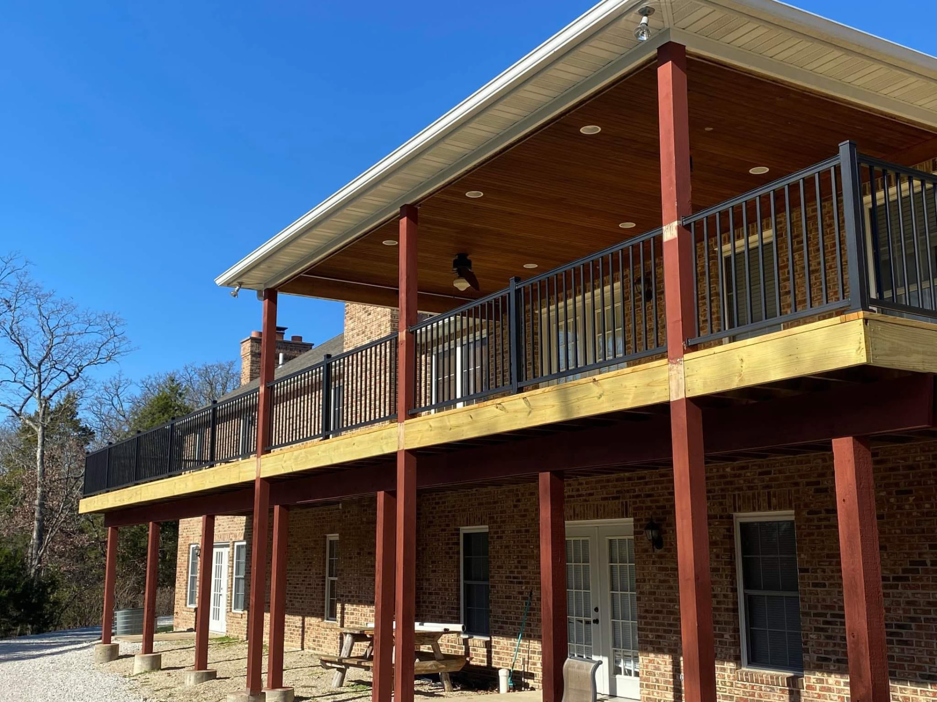 Deck resurface — demoed the old handrails and decking, rebuilt with new treated framing and maintenance-free black aluminum handrails, and cut the whole deck down 2" to match the existing covered porch posts with an all-new band board by B&R Construction